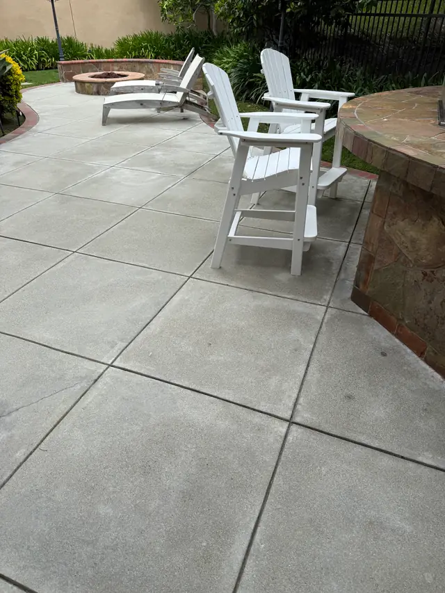 Clean concrete patio with white Adirondack chairs