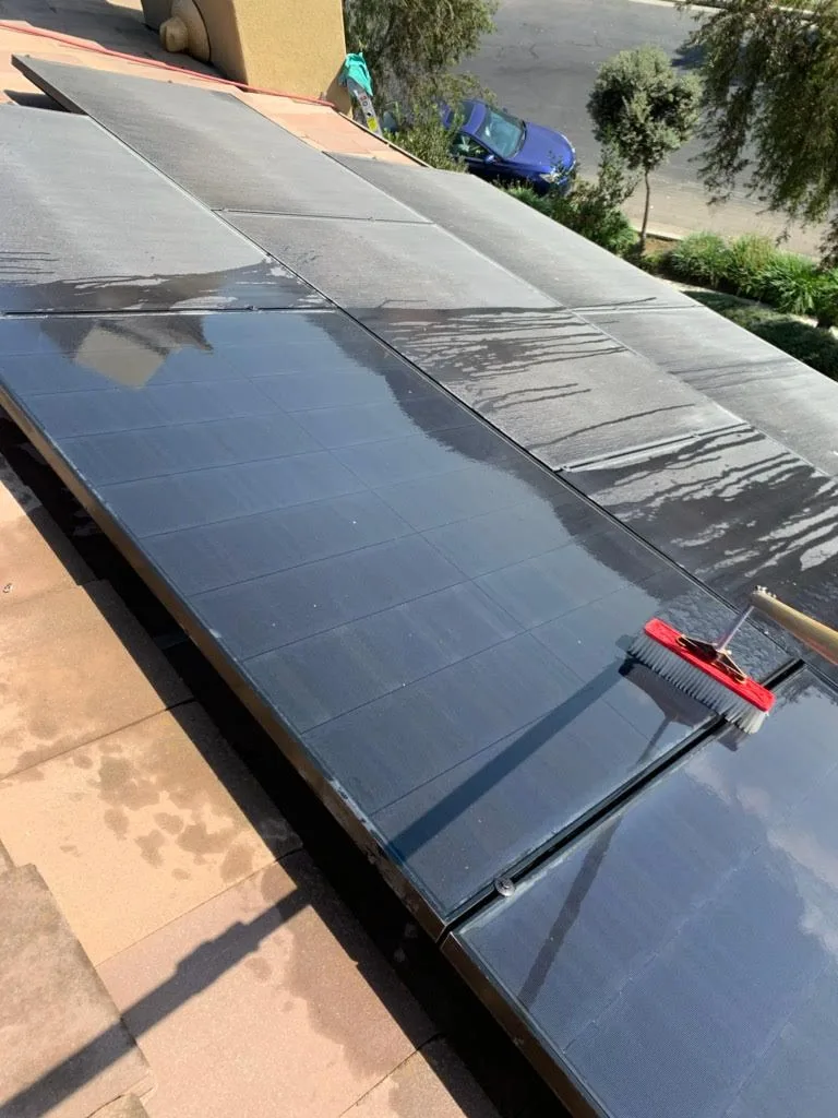 Squeegee mid-pass across a rooftop solar array