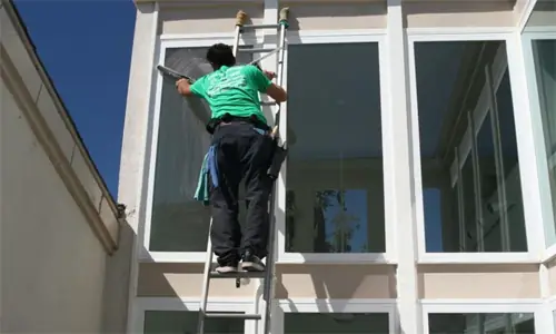 Technician on a ladder at a two-storey sunroom